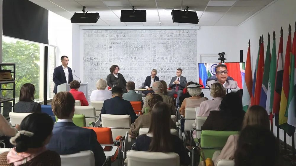 Panelová diskusia a delegáti oslavujúci dvadsať rokov fungovania BRICS v Moskve.